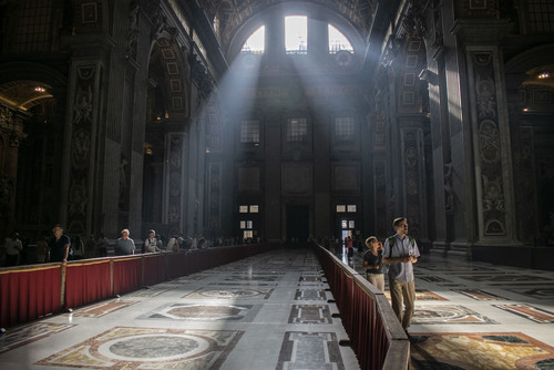 Bazylika św. Piotra w Watykanie widziana od środka z wpadającymi promieniami słońca przez witraże