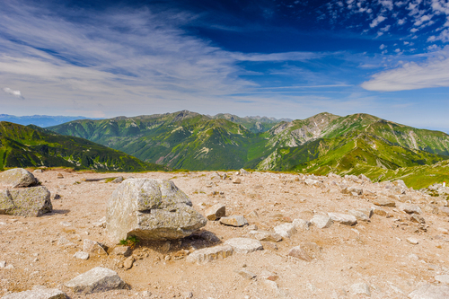 Zdjęcie zrobione latem w polskich Tatrach. Na pierwszym planie skały w tle szczyty tatrzańskie.