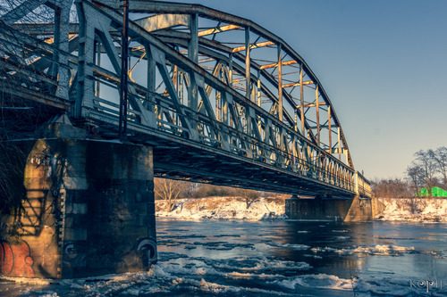 Most kolejowy nad rzeką Odrą w Głogowie, woj. dolnośląskie, zimowy widok.