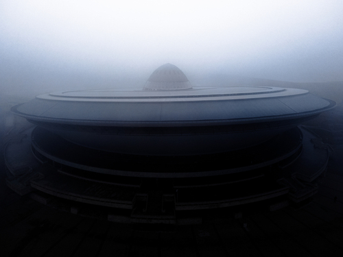 Fotografia wykonana za pomocą drona, przedstawia Spodek w Katowicach w porannej mgle