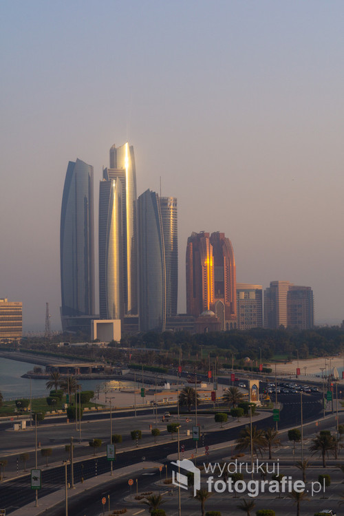 Wieżowce Abu Dhabi błyszczące w promieniach zachodzącego słońca. Zjednoczone Emiraty Arabskie. 31-07-2018