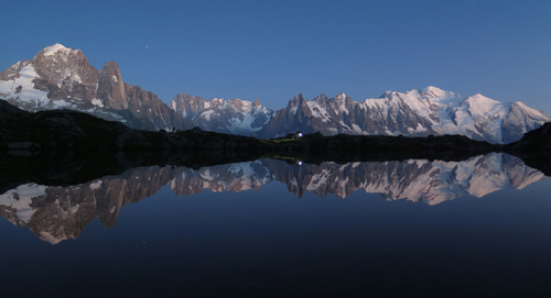 Lac de Cheserys nocą i odbijający się w jego tafli masyw Mont Blanc, Alpy Francuskie.
