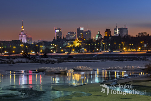 Night view of Warsaw downtown over Vistula river in winter time