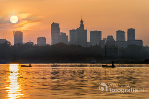 View of the Warsaw city center from the Vistula river at sunset.