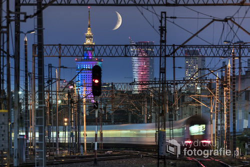 Partial moon over Warsaw city and train junction, Poland