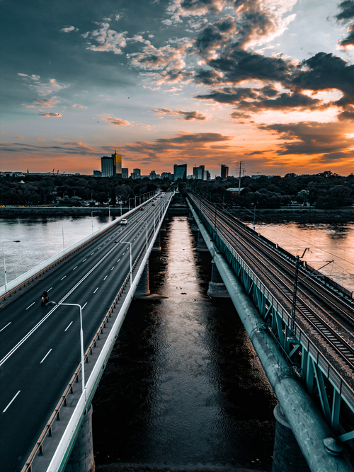 Zdjęcie mostu gdańskiego i cytadeli z drona ukazuje piękną panoramę Gdańska, gdzie nowoczesna architektura mostu kontrastuje z historycznymi umocnieniami cytadeli. To widok, który zachwyca zarówno miłośników nowoczesnego designu, jak i historii miasta.