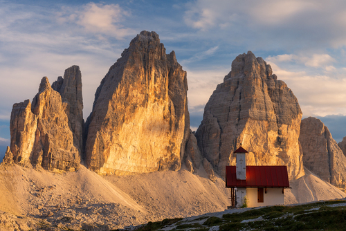 Kapliczka nieopodal Rifugio di Lavaredo we włoskich Dolomitach ze słynnymi szczytami Tre Cime w tle. Fotografia wykonana późnym popołudniem.