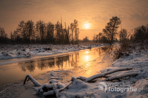 Zimowy zachód słońca nad rzeką Jeziorką