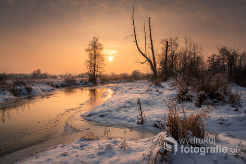 Zimowy zachód słońca nad rzeką Jeziorką