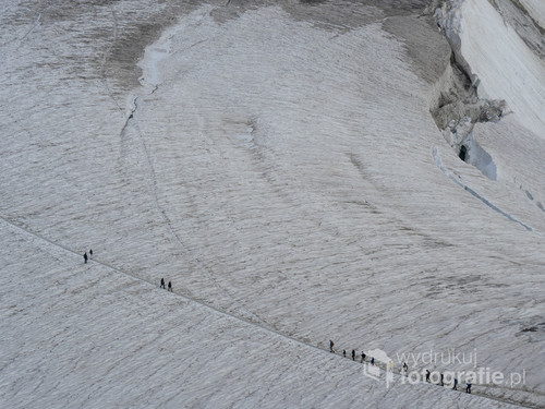 Zdjęcie zrobione na Punta Helbronner we Włoszech. PRzedstawia grupę alpinistów przemierzających lodowiec. 