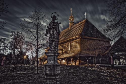 Drewniany kościół w Czarnowąsach (woj. opolskie) i stojąca na przyległym cmentarzu figura św. Jana Nepomucena, świadcząca o tym, że niedaleko płynie rzeka Odra