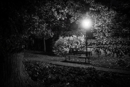Pusta ławka w parku nocą oświetlona latarnią