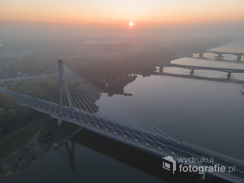 Zdjęcie wykonane o wschodzie słońca z widokiem na mosty Warszawy oraz Stadion Narodowy