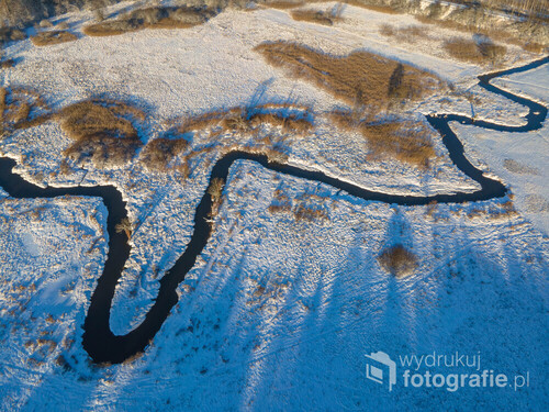 Fotografia wykonana za pomocą drona podczas słonecznego, zimowego poranka nad rzeką Jeziorką.