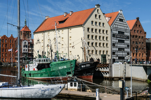 Kutry rybackie i jacht w marinie w Gdańsku. Na drugim planie dawne spichrze. Mieści się tam Narodowe Muzeum Morskie. W tle kamienice nad Motławą i kościół św. Jana