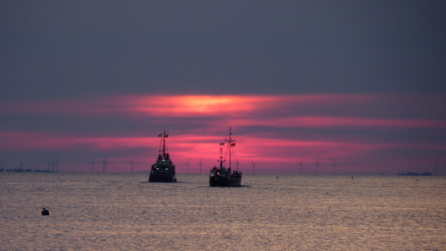 Dwa kutry rybackie na wodach Zatoki Puckiej na tle zachodzącego słońca