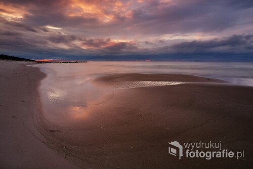 Jesienny zachód słońca na wybrzeżu Morza Bałtyckiego. Plaża w Dźwirzynie, Polska.