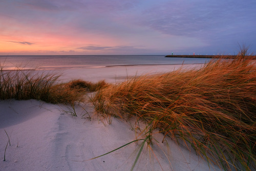 Krajobraz wybrzeża Morza Bałtyckiego o zachodzie słońca, Kołobrzeg, Polska.
