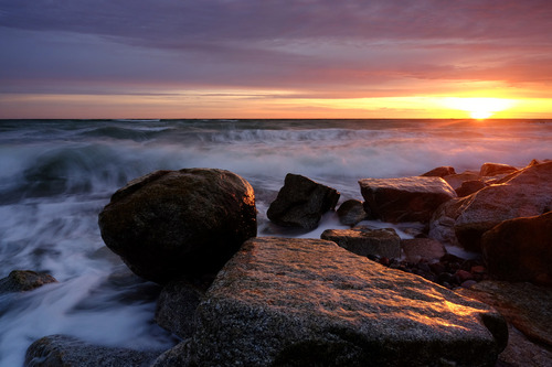 Kamieniste wybrzeże Morza Bałtyckiego o wschodzie słońca, Kołobrzeg ,Polska.