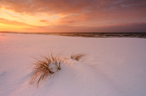 Zimowe wybrzeże Morza Bałtyckiego , w świetle zachodzącego słońca, Kołobrzeg, Polska.
