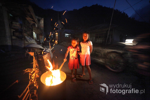 Dziewczynki bawiące się ogniem na ulicach tradycyjnej wioski na północy Bali.