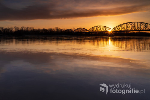 Fotografia przedstawia most kolejowy w Górze Kalwarii, wykonane zostało 22.02.2020 przy wschodzie słońca
