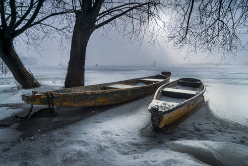 Zimujące nadbużańskie łódki na zamarzniętym Bugiem. Zdjęcie wyróżnione w ogólnopolskich konkursie 