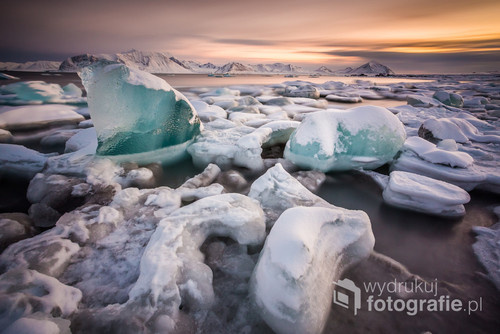 Arktyka, Spitsbergen - bryły turkusowego lodu lodowcowego na zamarzniętej plaży