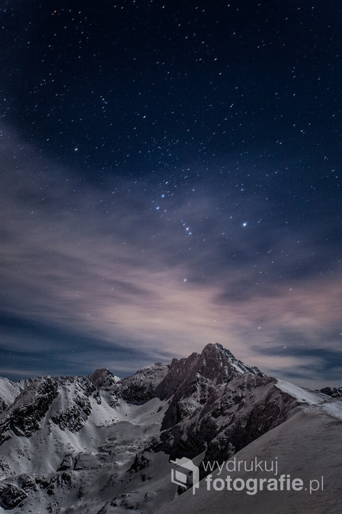 Zima w Tatrach - gwiazdozbiór Oriona zawieszony nad ośnieżonym szczytem Świnicy