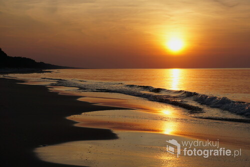 Spokojne morze i piasek oświetlone złotymi promieniami wrześniowego słońca na Mierzei Wiślanej