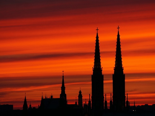 Sylwetki wież katedry św. Floriana Męczennika i św. Michała Archanioła na warszawskiej Pradze-Północ na tle chmur zabarwionych na czerwono przez zachodzące słońce.