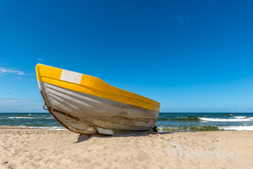 Klasyczny nadmorski widok- samotna łódź rybacka czekająca na plaży na przypływ i kolejny połów. Nadgryziona zębem czasu a jednak wciąż piękna mimo swej prostoty. patrząc na to zdjęcie słychać szum morza i czuć ciepło bijące od piasku.