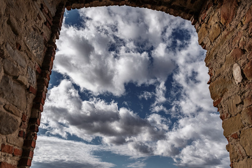Widok z okna wieży Klasztoru Karmelitów bosych w Zagórzu na chmury biegnące po błękicie nieba.