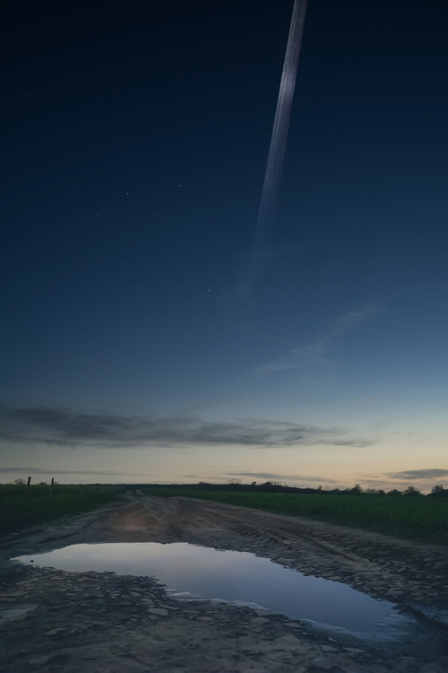 Przelot satelitów z 24 grupy Starlink nad polem w Michalczy k. Gniezna. Na przelatujących obiektach udało się uchwycić obraz Słońca będącego nisko pod horyzontem.