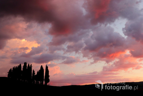 Zmierzch nad Toskanią, ostatni blask słońca na chmurach. Cyprysy są wieczne.