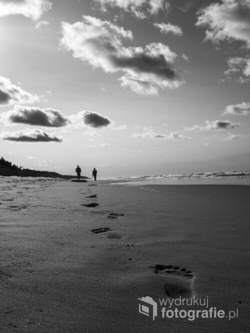 Ludzie spacerujący brzegiem morza