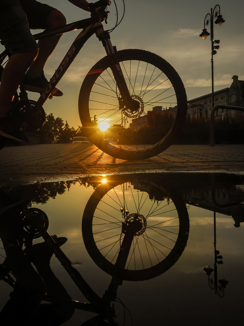 Zachód słońca i przypadkowy rowerzysta złapany w kadrze na ulicy w Bydgoszczy