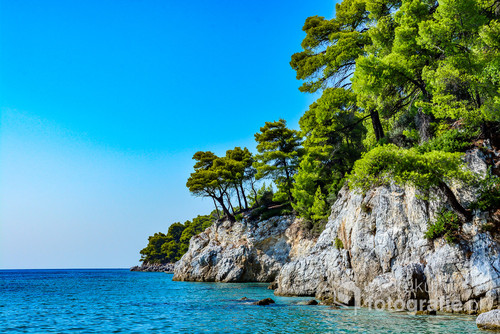 Zdjęcie przedstawia przepiękne skaliste wybrzeże malutkiej Greckiej wysepki Skopelos, na której kręcono słynny musical Mamma Mia. Zostało zrobione z plaży Kastani, na której kręcono niektóre ze scen filmu.