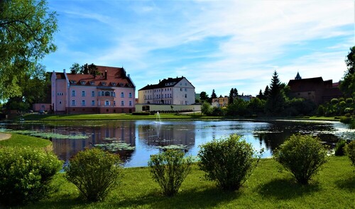 Fotografia została wykonana w mieście Barczewo woj., warmińsko-mazurskie jest to budynek zamku nad jeziorem z fontanną .