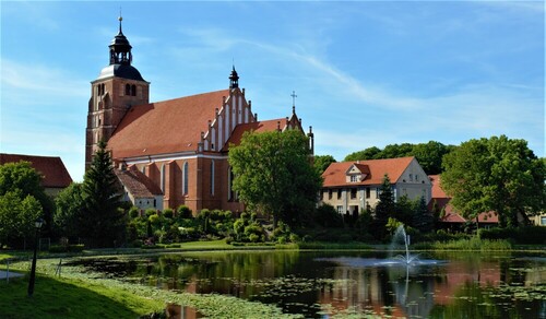 Miasto Barczewo woj., warmińsko-mazurskie kościół nad małym jeziorem z fontanną .