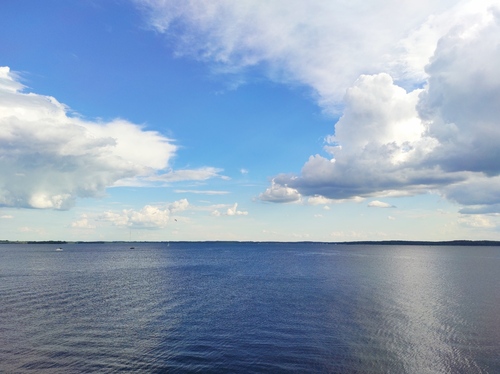 zdjęcie przedstawia jezioro i niebo piękno natury rożnych odcieniach niebieskiego koloru z odrobiną bieli 