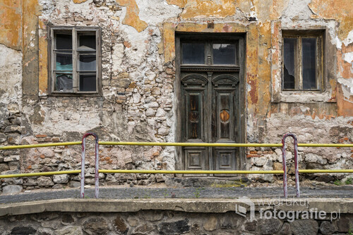 Słowacja - Kremnica. Opuszczony i niszczejący dom z oryginalnymi, zabytkowymi drzwiami. Brak tynku ukazuje oryginalną strukturę ścian budynku i materiały z jakich powstał.