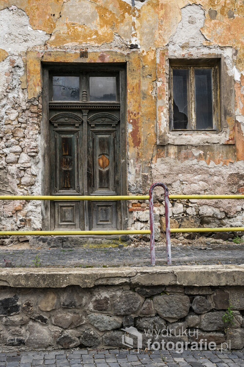 Słowacja - Kremnica. Opuszczony i niszczejący dom z oryginalnymi, zabytkowymi drzwiami. Brak tynku ukazuje oryginalną strukturę ścian budynku oraz materiały z jakich powstał.
