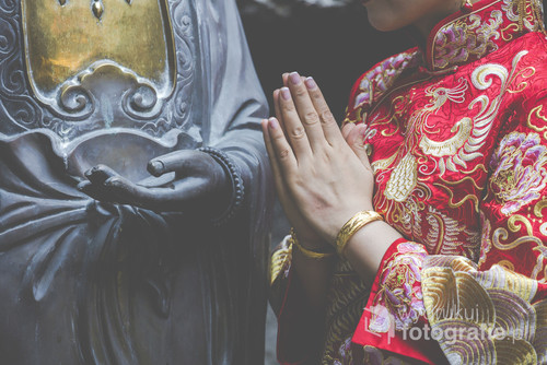 Woman hand respect to buddha statue.


