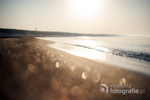 Poranek na słonecznej plaży w Ustce. Spokojne i niezmącone morze zachęca do spacerów.