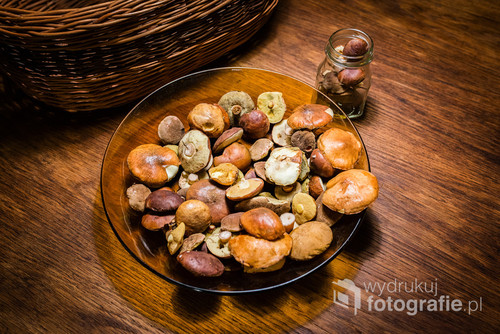 Glass plate with raw mushrooms on the wooden table.