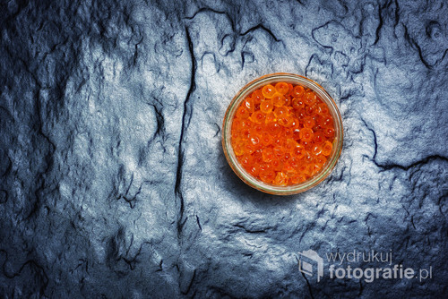 Red caviar in a jar on a stone slab. View from above. Czerwony kawior na kamiennej płycie.