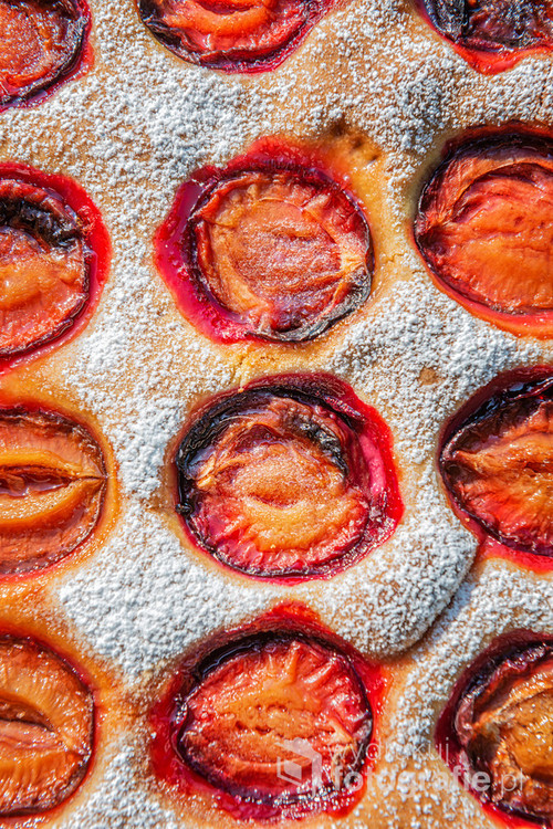 Cake with plums on a roasting dish.