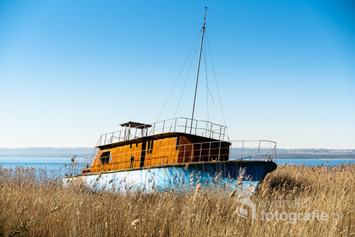 The wreck of a small ship, abandoned on the shore of the lake.
