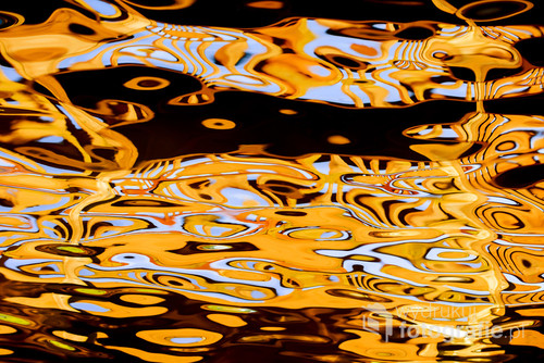 Abstract, colorful reflections in the water. Sunset. Curved lines.